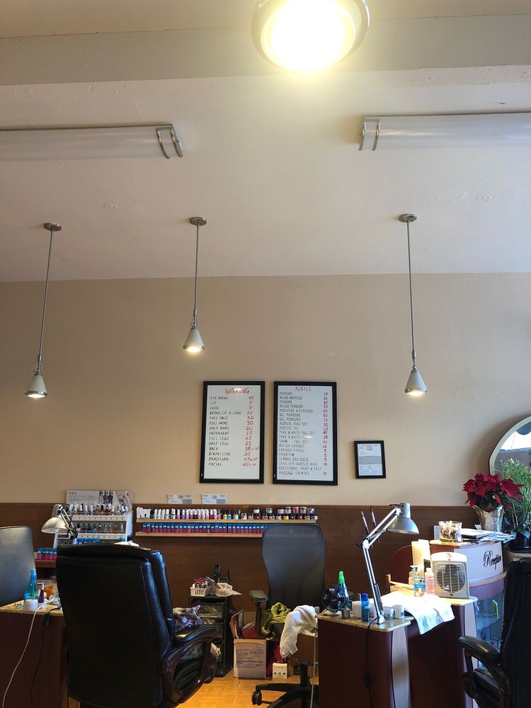 Manicure stations and the shop’s handwritten nails and waxing boards.