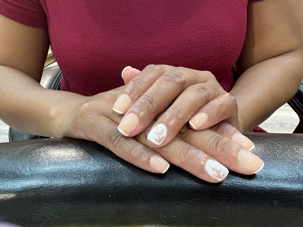 Short French manicure with a faint leaf accent.