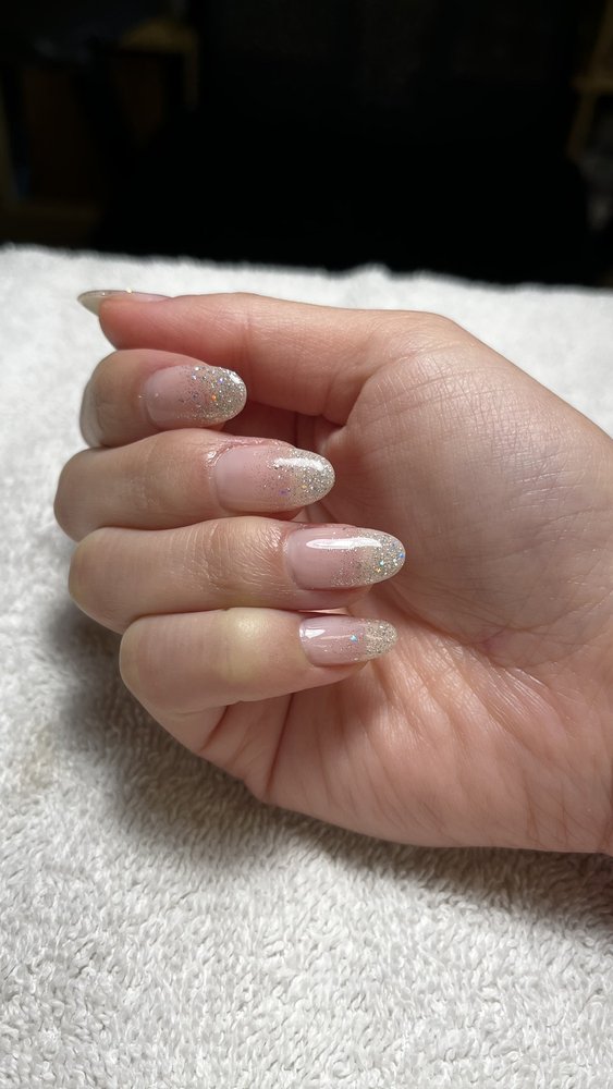 Sheer glitter French manicure on a white towel.