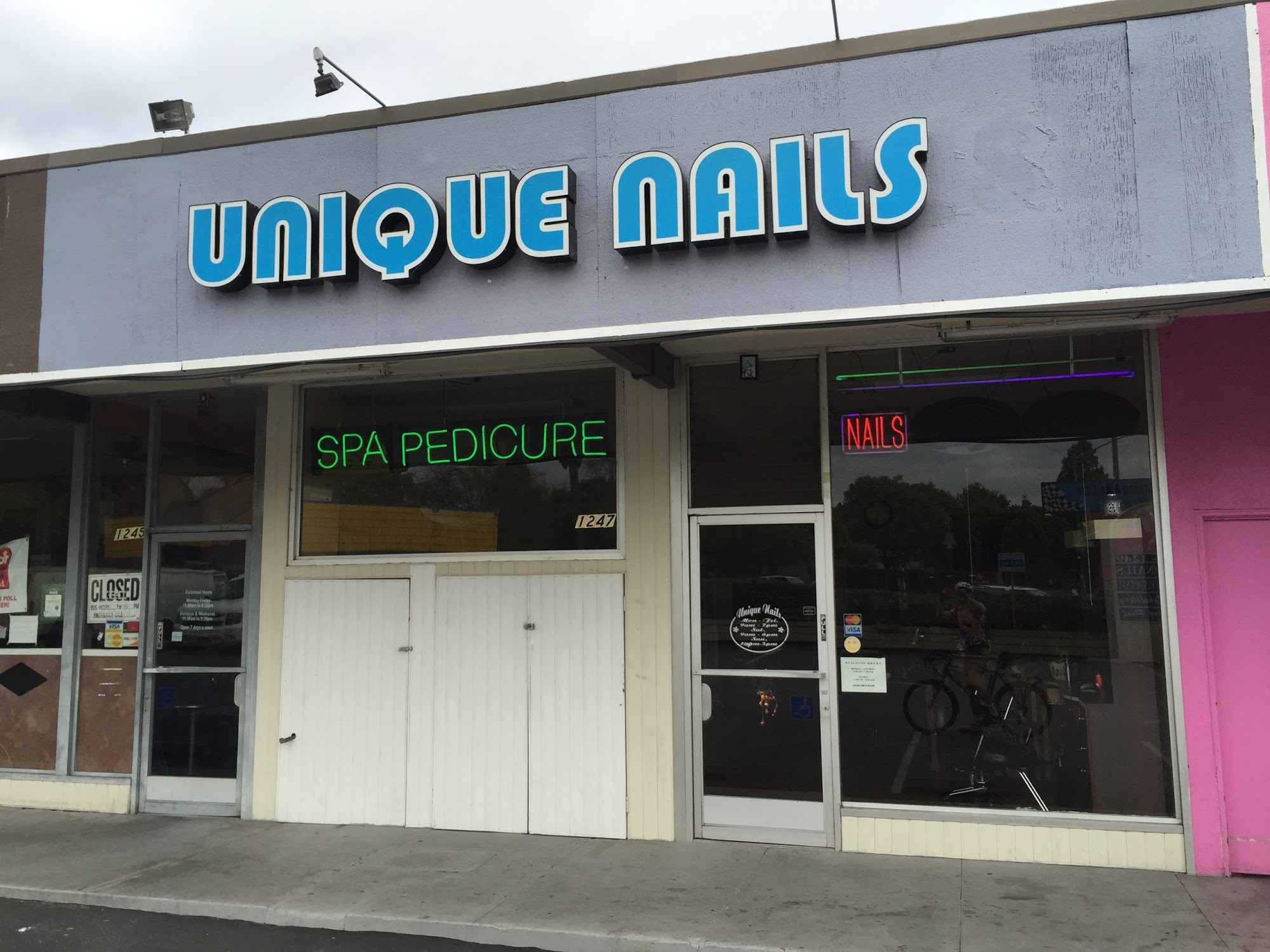 Unique Nails storefront at 1247 W El Camino Real, Mountain View — blue UNIQUE NAILS letters above SPA PEDICURE and NAILS neon.